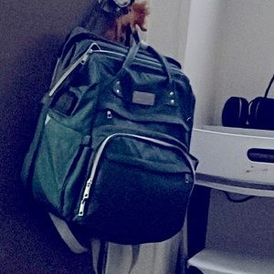 Green diaper bag with a travel bed built inside it